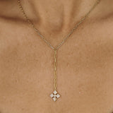 Gold chain necklace with a diamond cross pendant on a person's neck