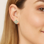 Close-up of a woman wearing a floral earring with a neutral background
