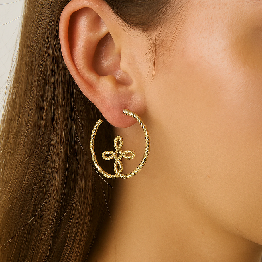 Close-up of a person wearing gold hoop earrings and a gold chain necklace.
