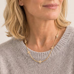 Woman wearing the Believer Cross Mini Necklace by Natalie Wood Designs